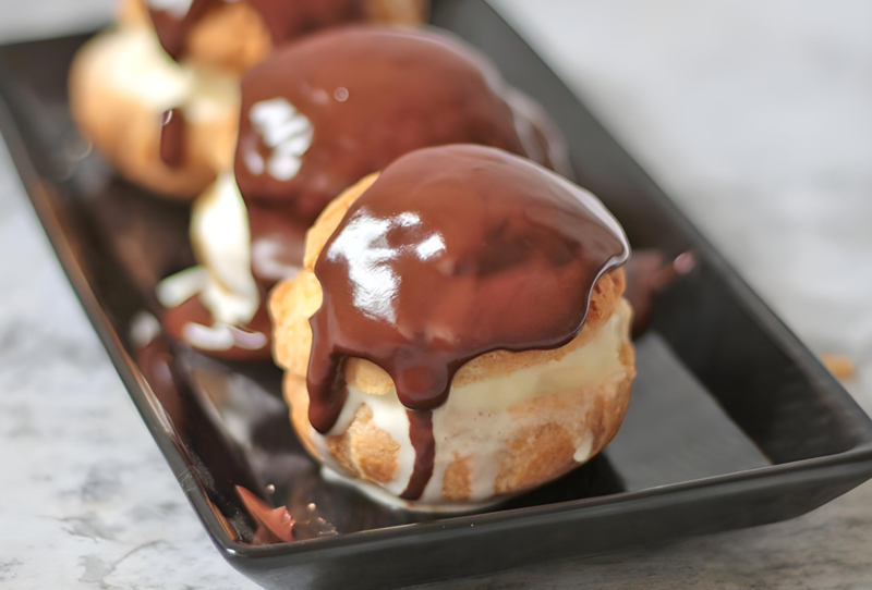 Bánh su kem Profiterole được phủ lớp sốt socola với lớp nhân thơm béo ở giữa (Nguồn: A Baking Journey)