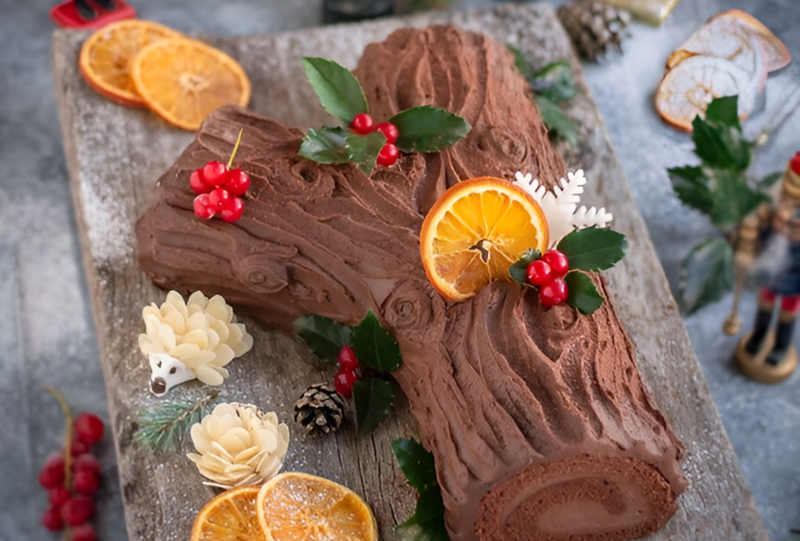 Bánh Yule log cake được trang trí với cây nhựa ruồi,quả thông tạo hình thú mới lạ và các lát cam mỏng (Nguồn: Pinterest)